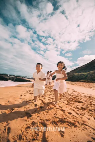Kids running on a sandy beach in Hawaii