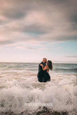 Couple kissing in the ocean waves in Hawaii