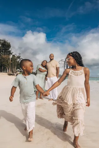 Family walking hand in hand on the beach in Hawaii