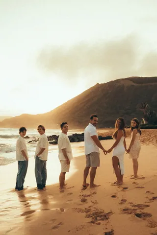 Family holding hands on the beach at golden hour in Hawaii