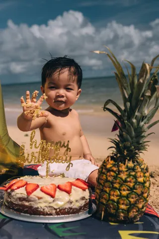 Baby first birthday cake smash with a pineapple on the beach in Hawaii