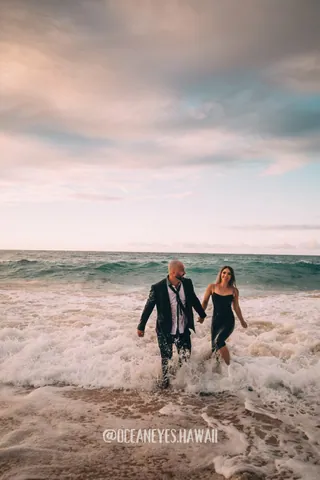 Couple walking out of the ocean waves in Hawaii