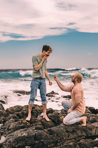 Surprise proposal on lava rocks by the ocean in Hawaii
