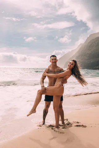 Couple embracing on the beach after saying yes in Hawaii
