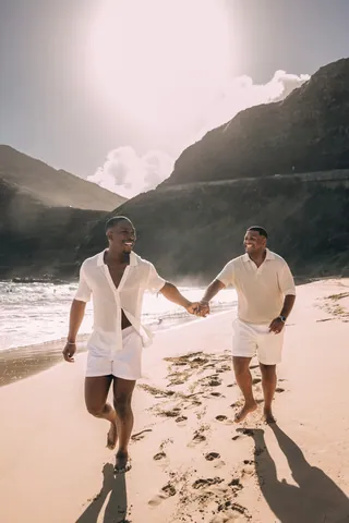 Couple walking hand in hand along the shoreline in Hawaii
