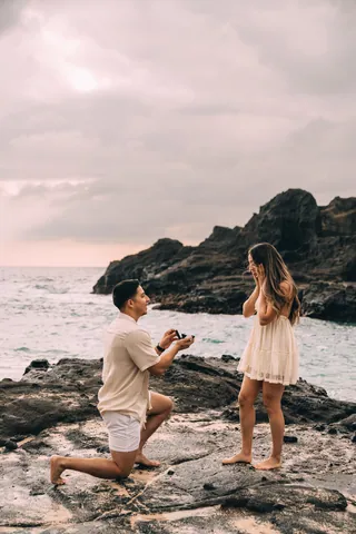 Surprise proposal on lava rocks by the ocean in Hawaii