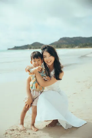 Mother hugging her son on the beach in Hawaii